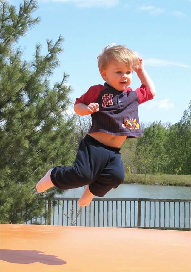 A joyful toddler catches some air on the jumping pillow at Great Country Farms.