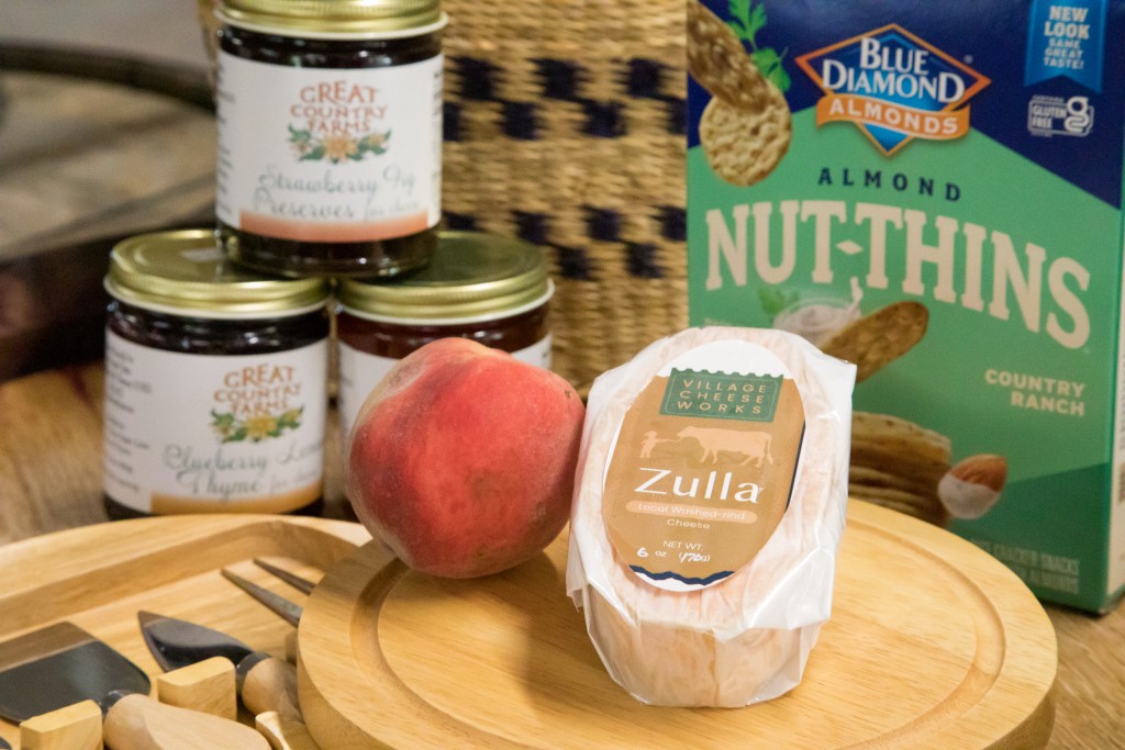 Zulla Cheese from Village Cheese works pictured in the Great Country Farms Market with fresh peaches and jams and jellies.